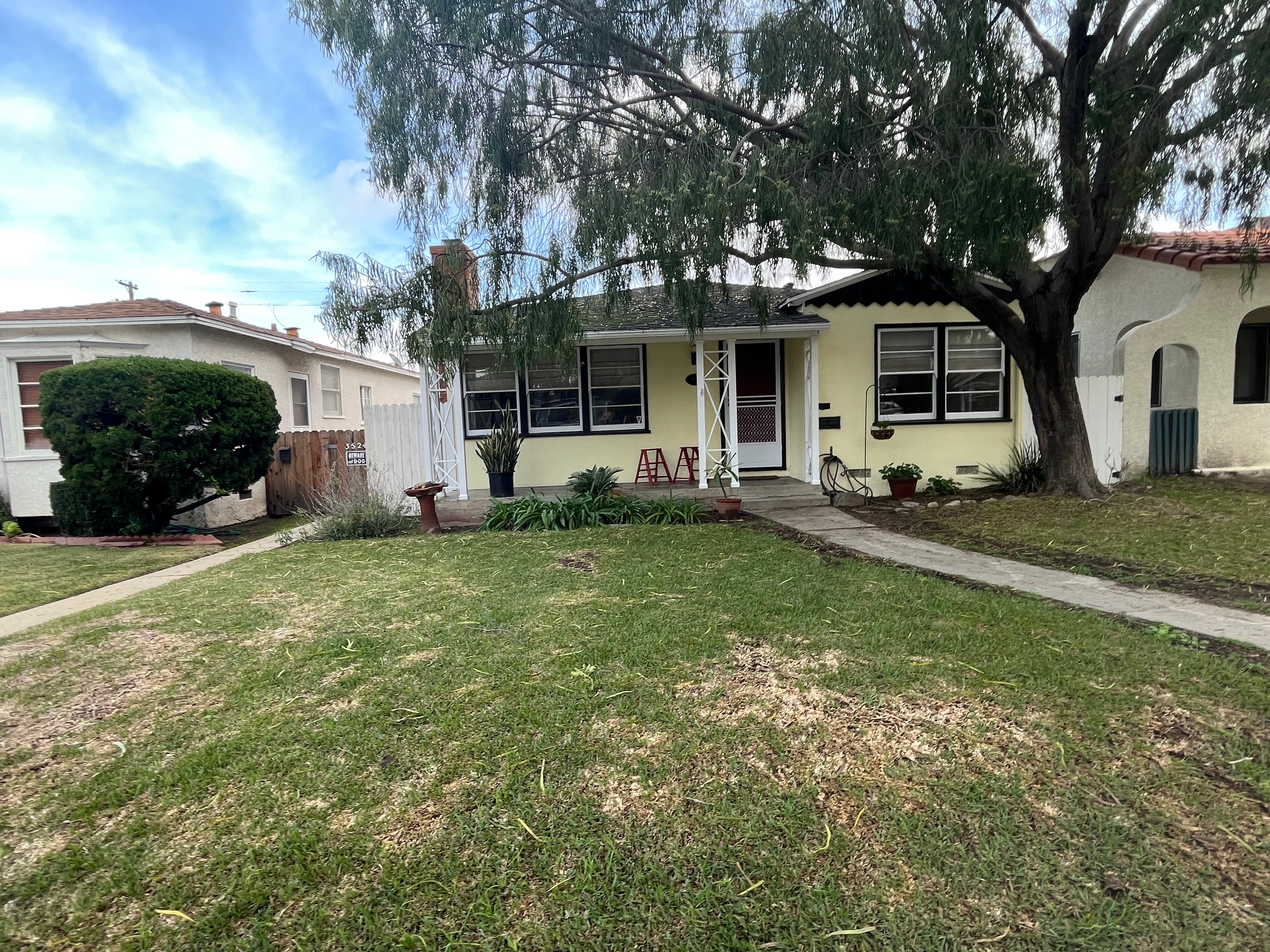 a yellow house with a grass lawn 