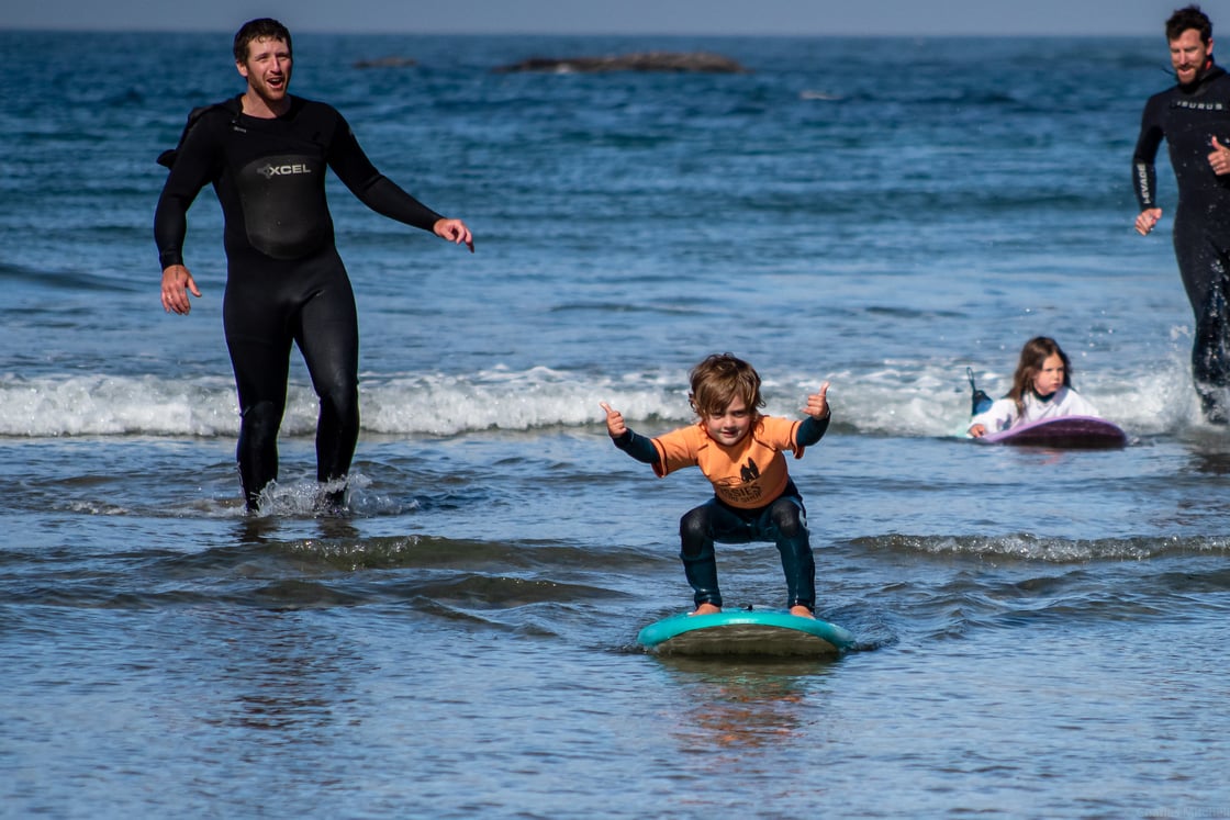 child surfing and giving a thumbs up at Otter Rock and Roll