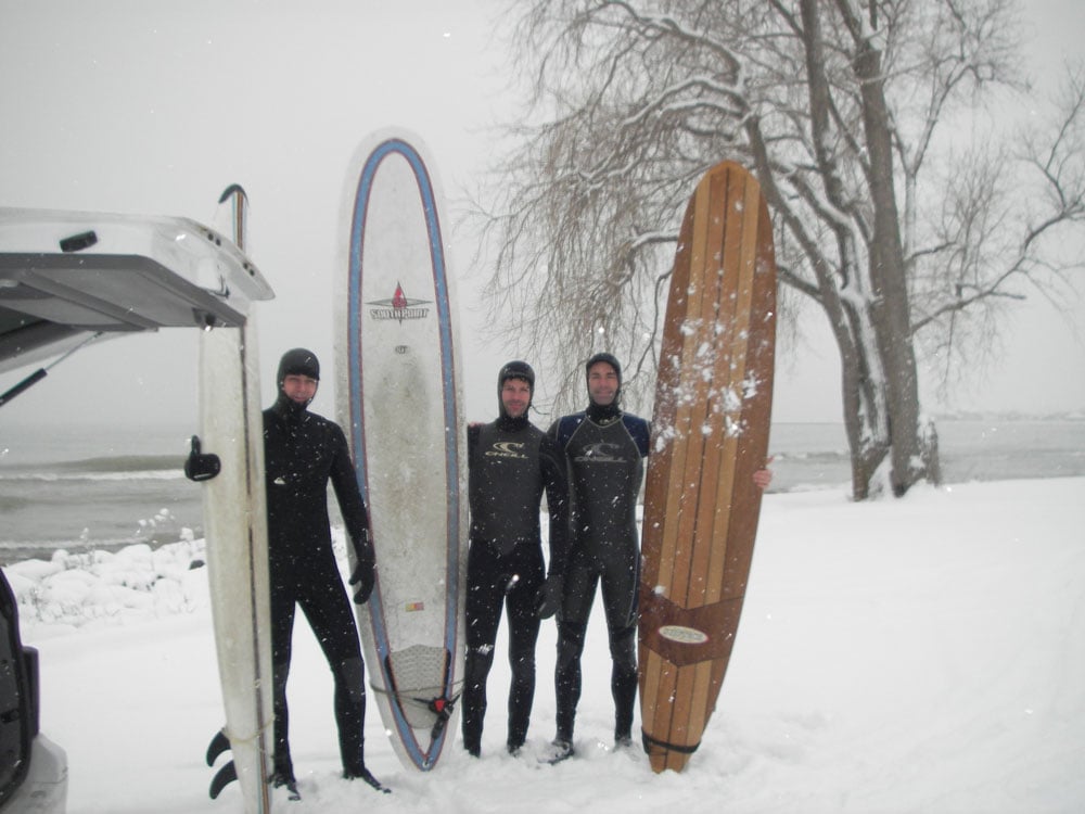 Nicholas Hade with the Milwaukee Chapter holding surfboards in the snow
