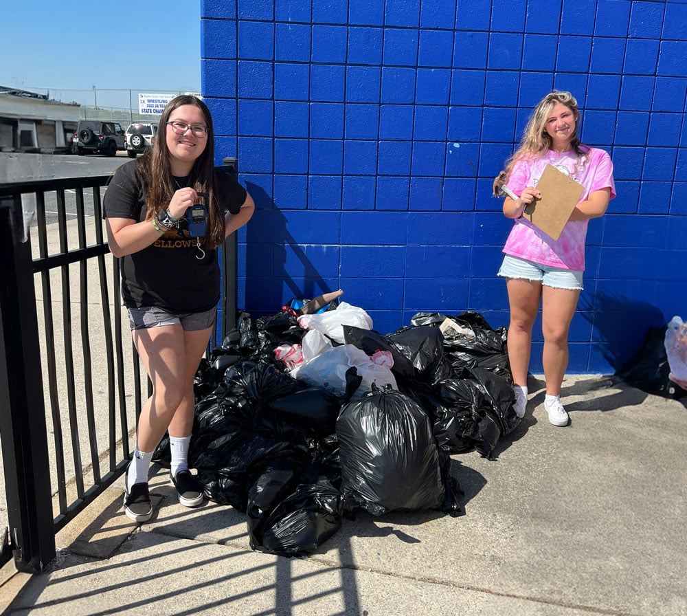 Stephen Decatur High School Surfrider Club holding trash that they collected at a Surfrider beach cleanup