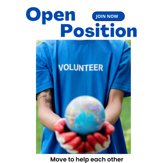 A volunteer wearing gardening gloves holds out a small ball of the world wearing a volunteer t-shirt