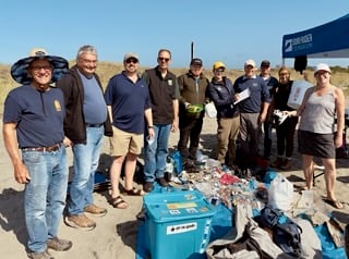 Our cleanup crew at International Coastal Cleanup day standing in front of a pile of trash