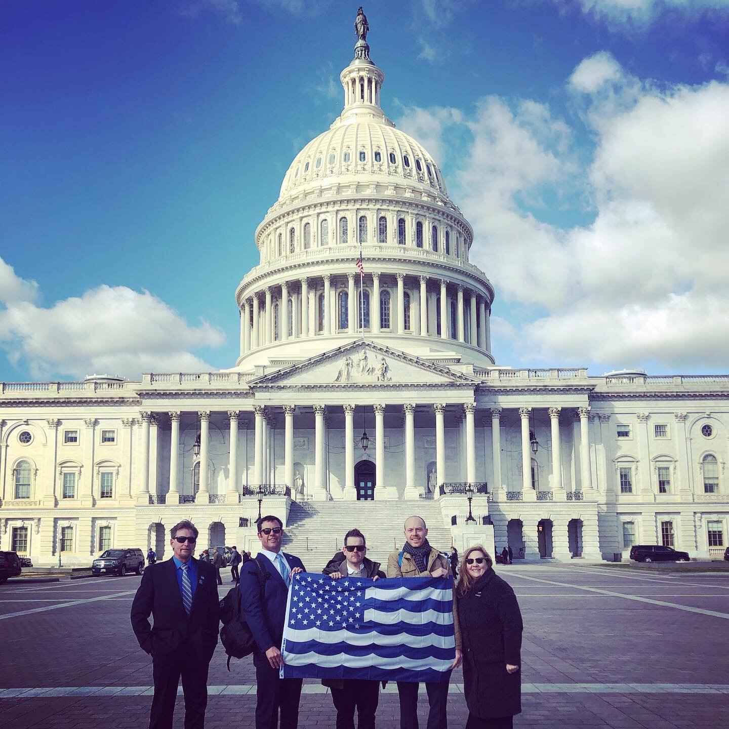 Our Washington delegation holds the United Oceans flag in front of the capitol building in DC