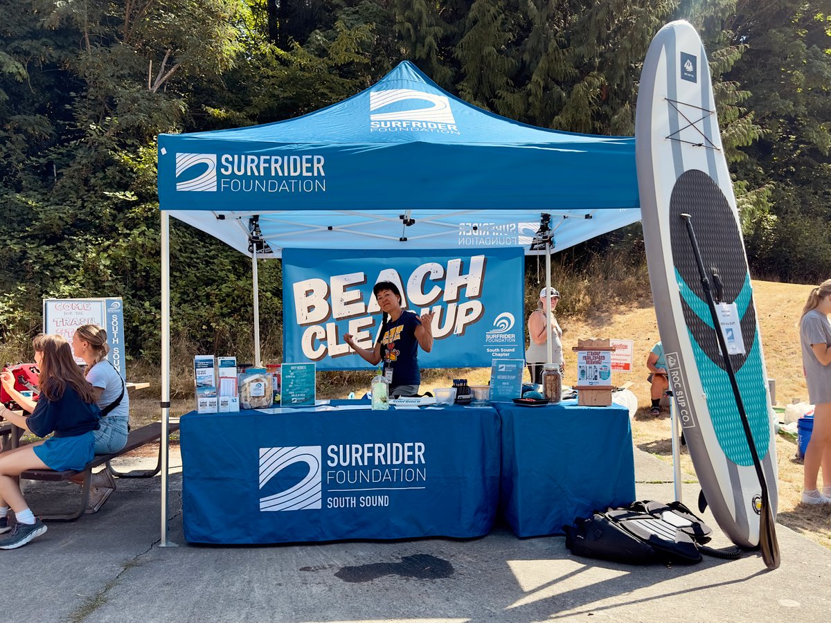 Bright blue Surfrider volunteer registration tent and table during a monthly beach cleanup 