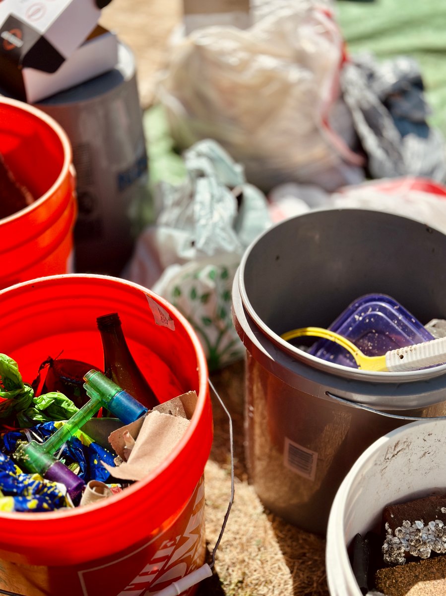 Close up view of trash collected in buckets at a monthly beach cleanup