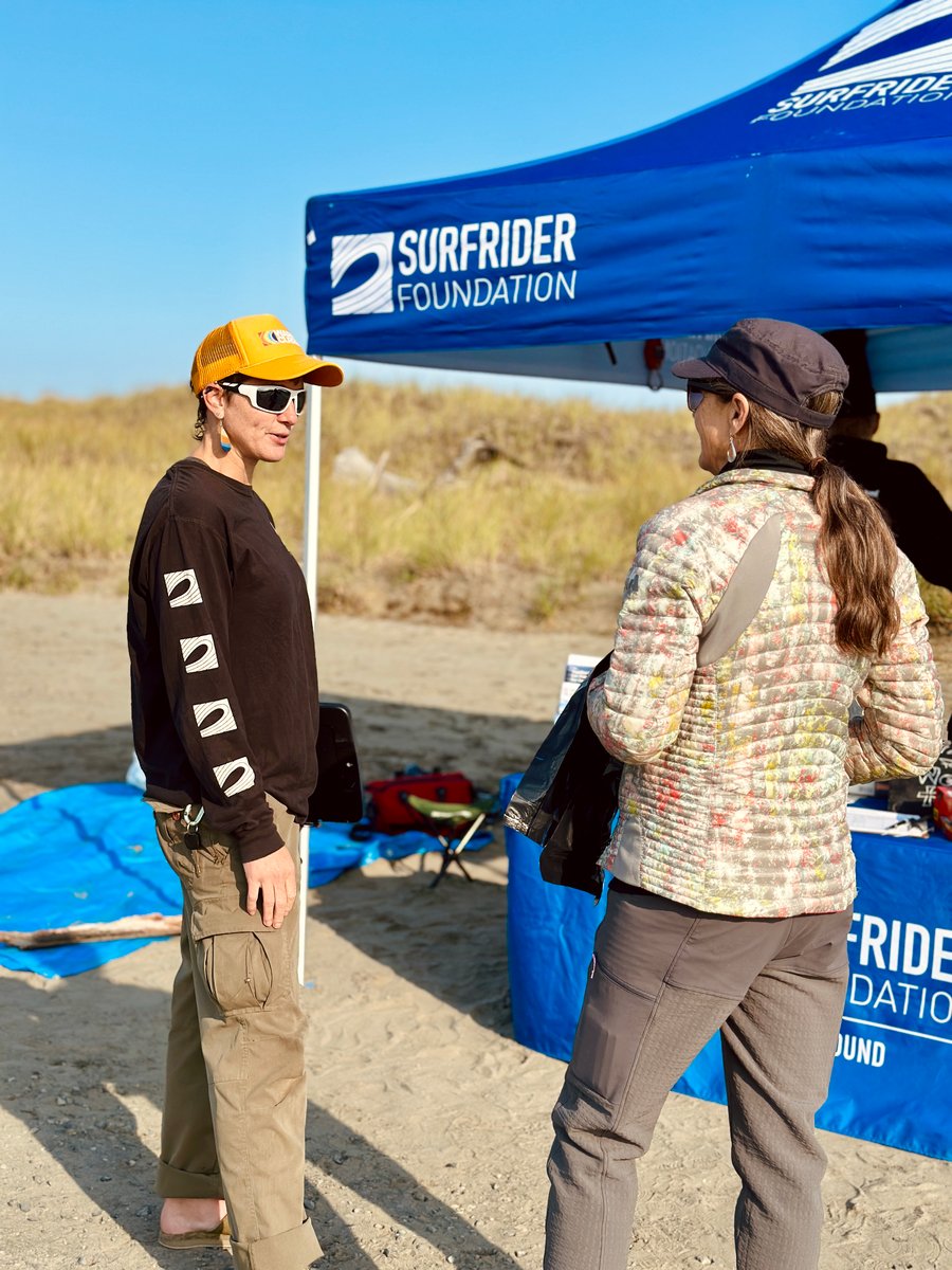 Female volunteer talking to another female about the purpose of Surfrider and joining in the monthly beach cleanup
