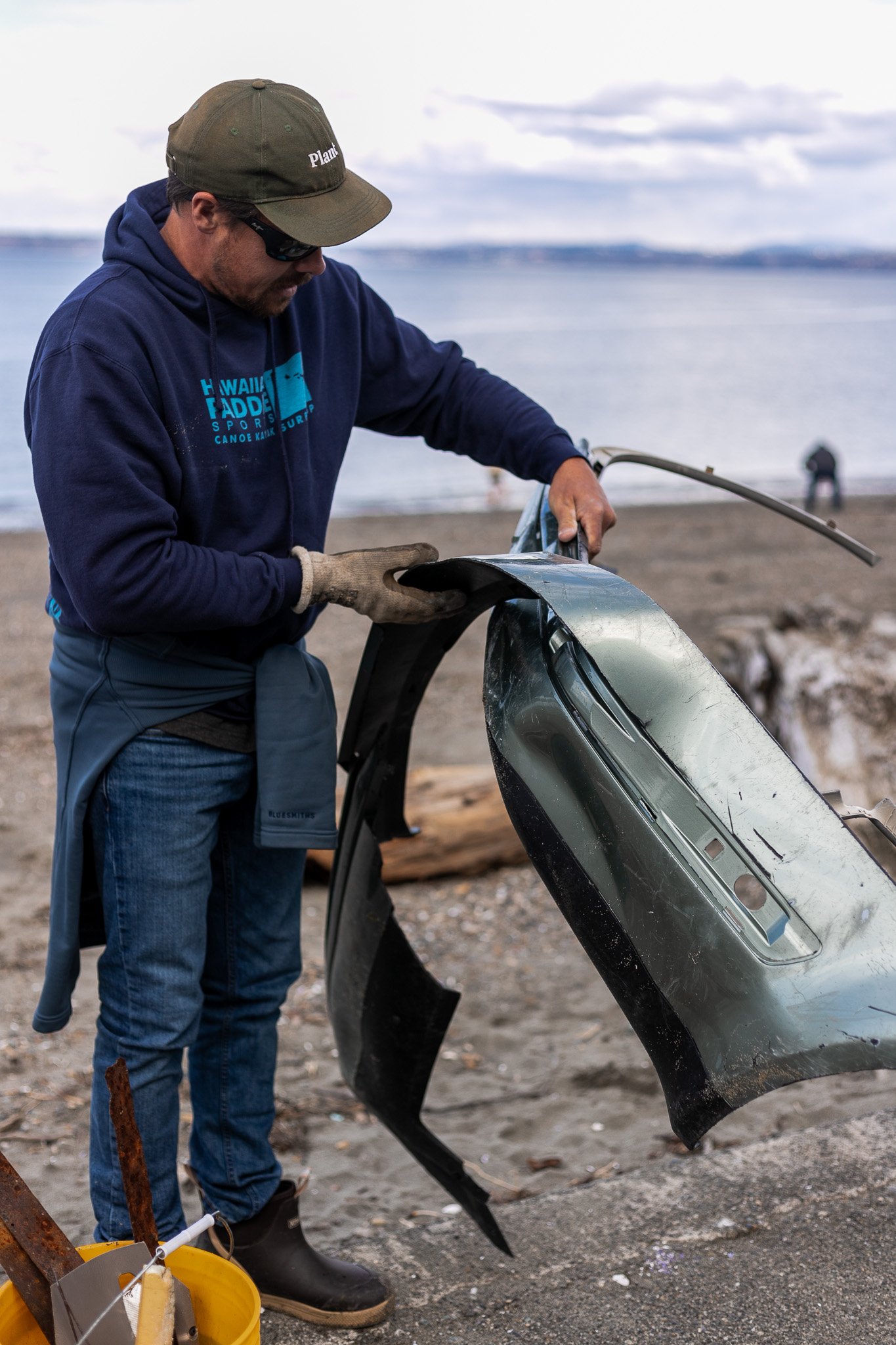 Male volunteer who found a car bumper during a monthly beach cleanup