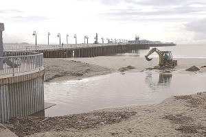 A backhoe loader is used to dig a channel from the Neary Lagoon Stormwater Outflow to the Monterey Bay at Cowell Beach last year. A working group studying contamination at Cowells considers the lagoon a potential source of bacteria. (Dan Coyro -- Santa Cruz Sentinel file) 