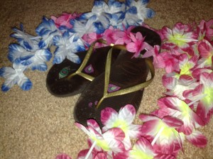 A pair of flip-flop sandals surrounded by leis