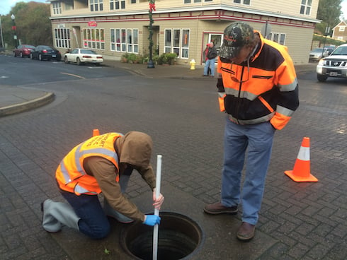 Leland uses a pole to collect samples, some 12 feet beneath the streets surface!
