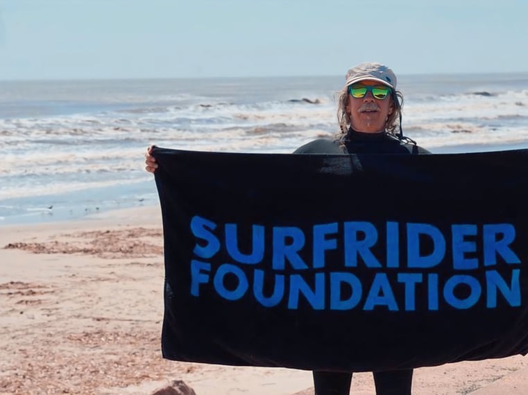 Jeff Sensheimer with the Galveston Surfrider Chapter holding a beach towel