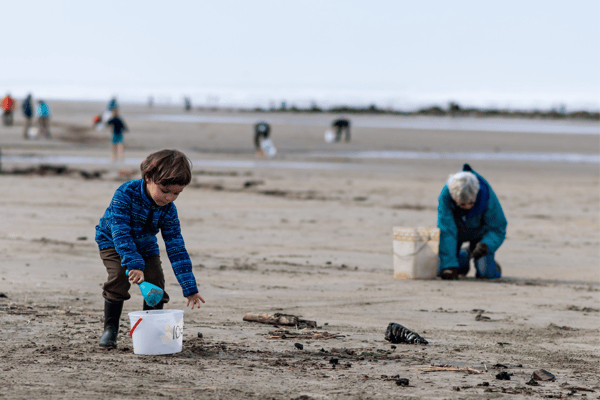 a child helps at a beach cleanup in Newport, OR