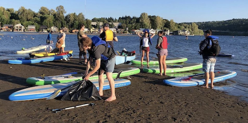 Photo of beach cleanup with stand up paddle boards