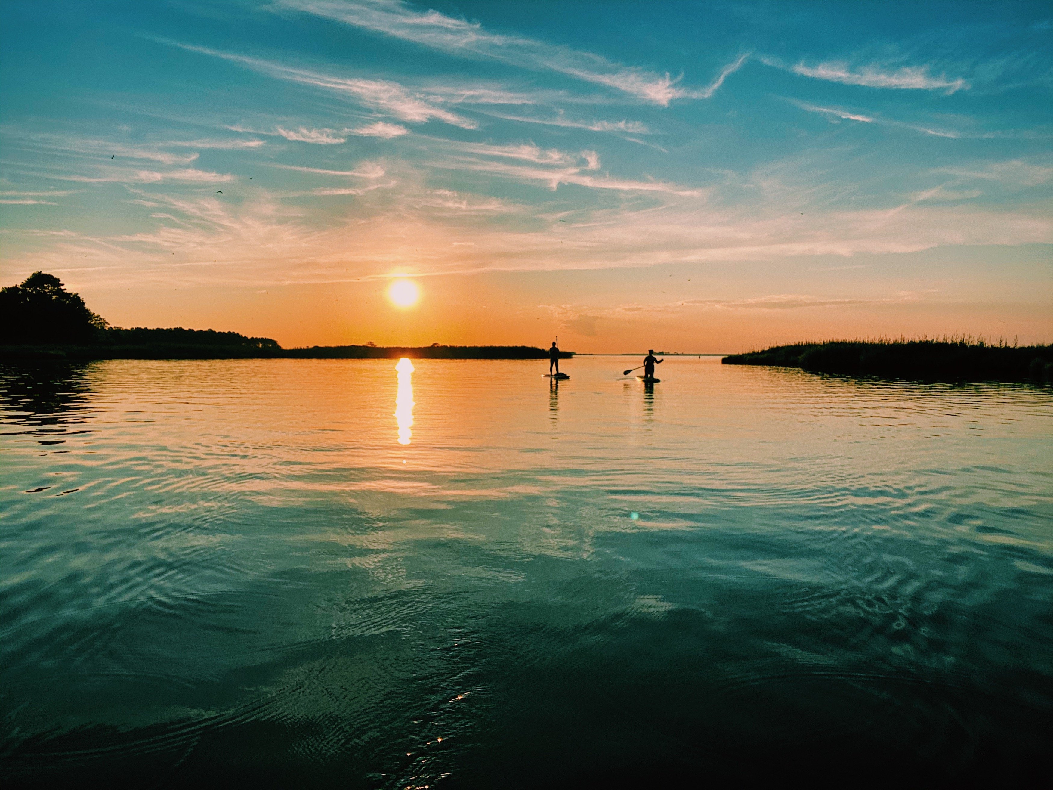 Two paddleboarders at sunset