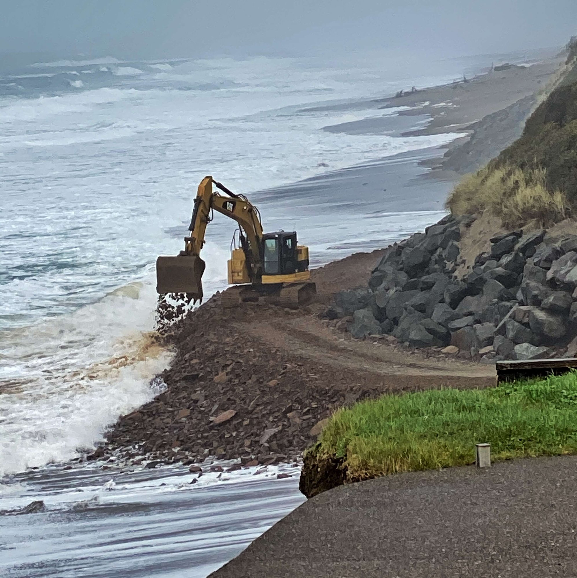 Bulldozer placing riprap on Gleneden Beach during a storm