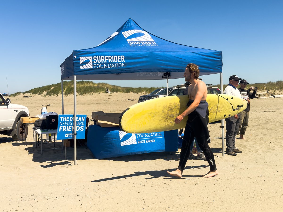 Surfer walking by Surfrider Tent at BCU-1