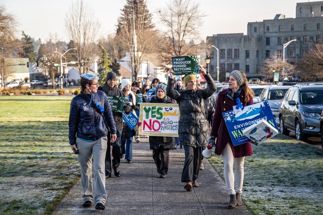Activists marching in front of the capitol building holding say no to plastics signs. Photo credit: Ricky Osborne