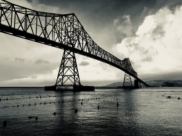 A black and white image of the Astoria bridge over the Columubia; Photo by Chris King on Unsplash 
