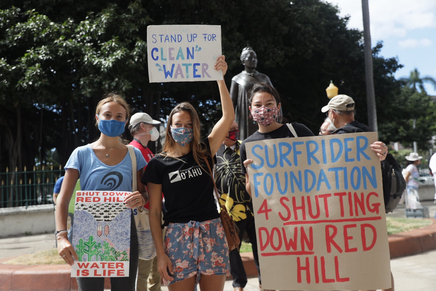 Surfrider Volunteers holding signs for justice at red hill rally