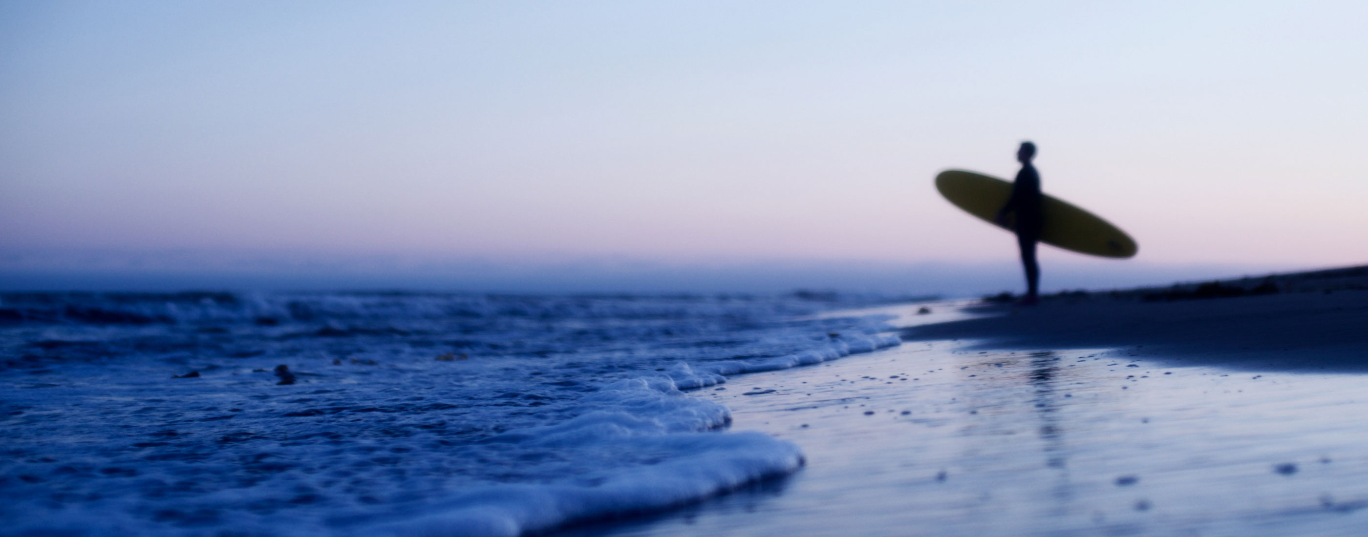 Surfer along the shore