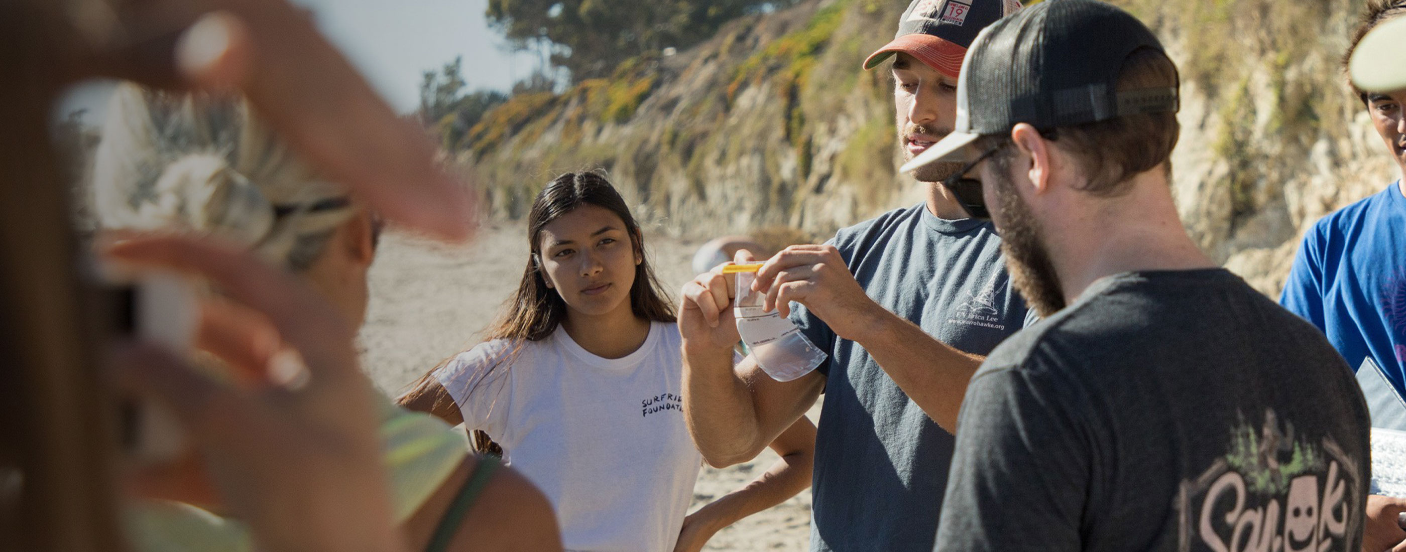 Volunteers-on-a-beach-receiving-instruction