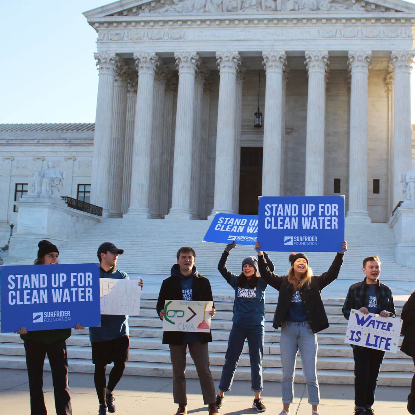 volunteers holding "stand up for clean water" signs outside the capitol building in D.C.