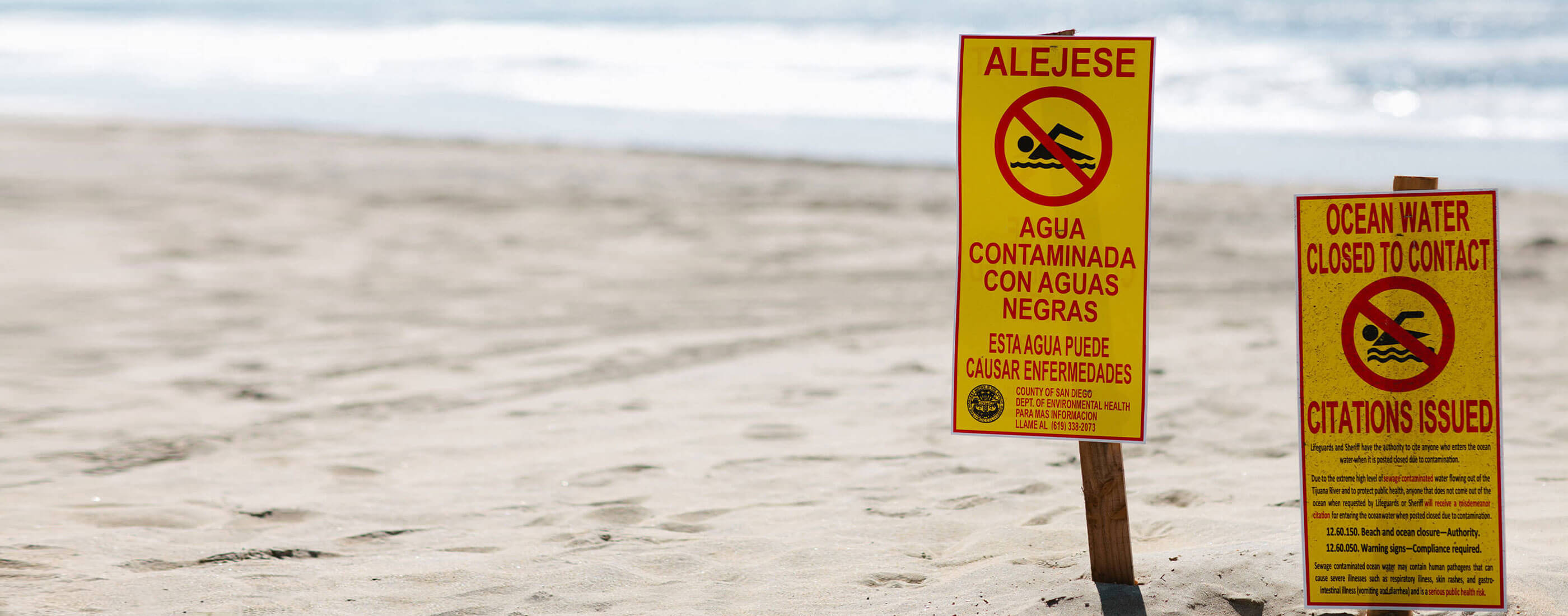 contaminated water warning signs at the beach