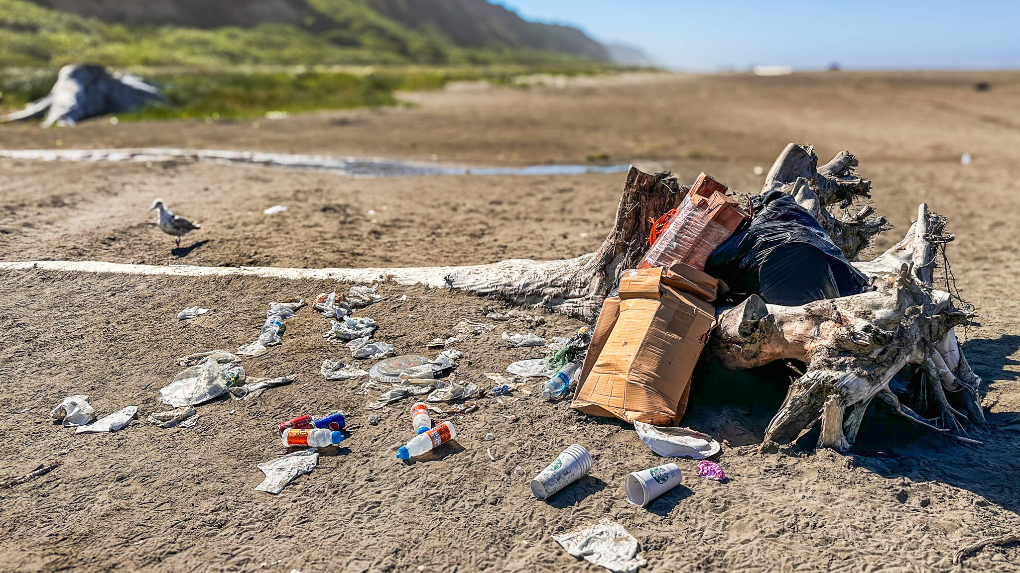 A pile of trash and litter purposely left on the beach at the Pacific Ocean