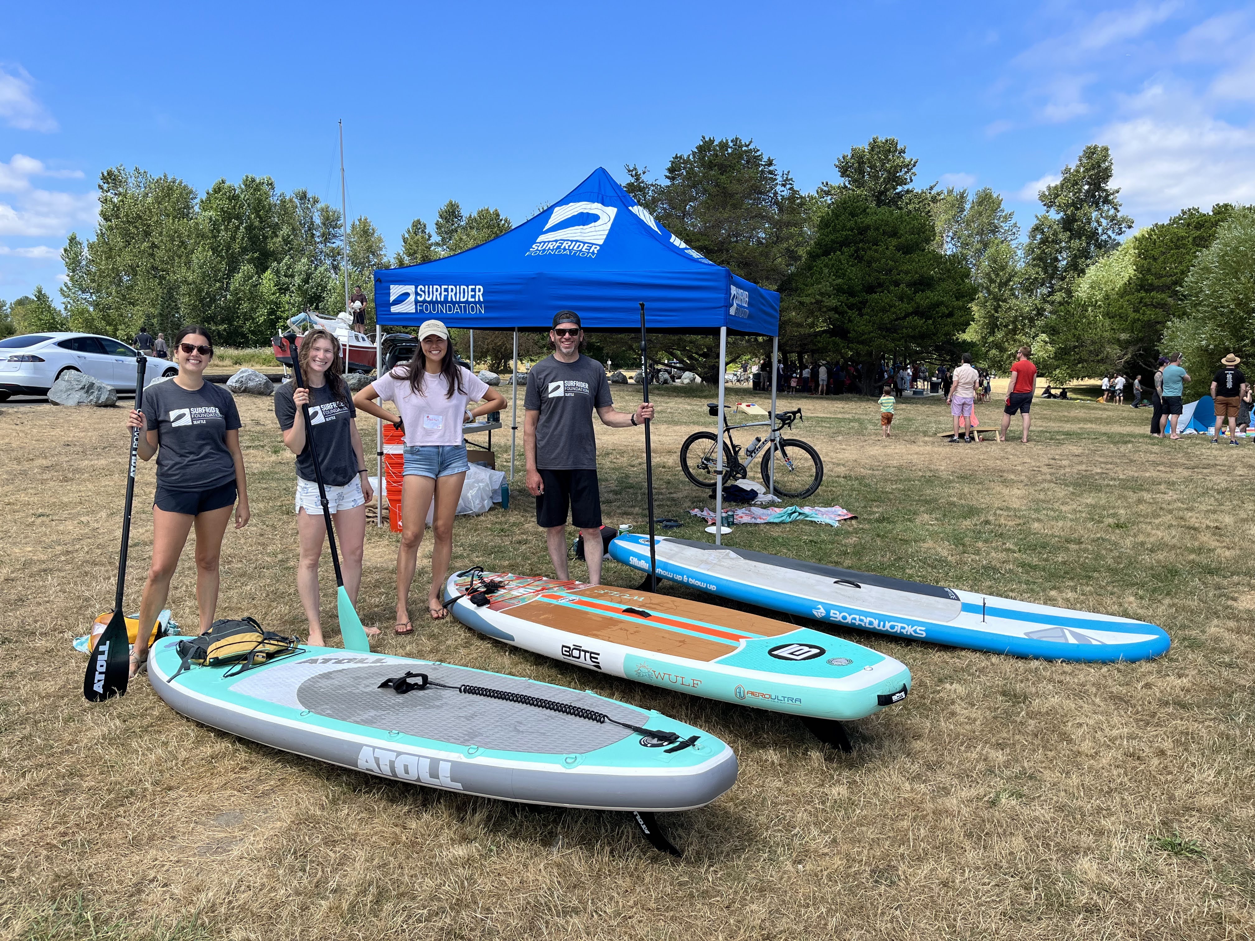 Members of Surfrider Seattle Chapter stand with paddle boards at Clean and Cruise event.
