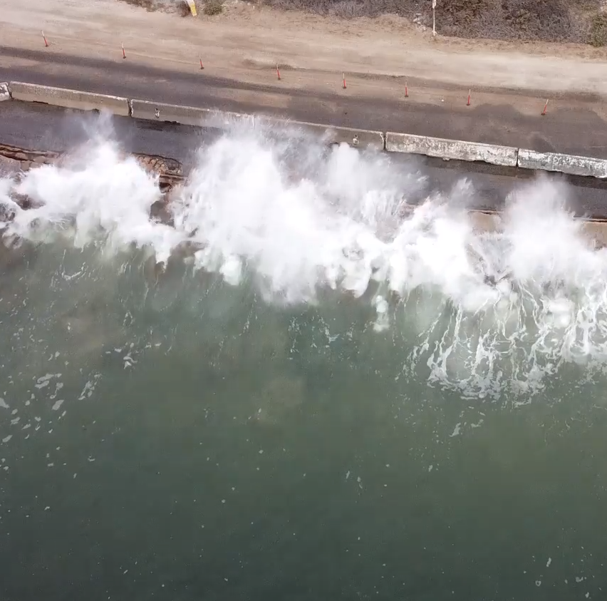A wave crashing over coastal armoring at the Rincon Parkway