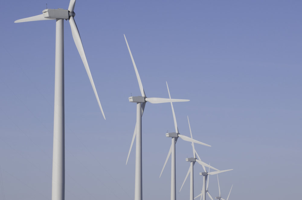 Tops of wind turbines against a wintry blue sky in northern Illinois