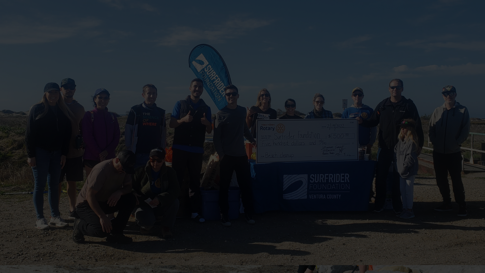 A local business posing at their beach cleanup.