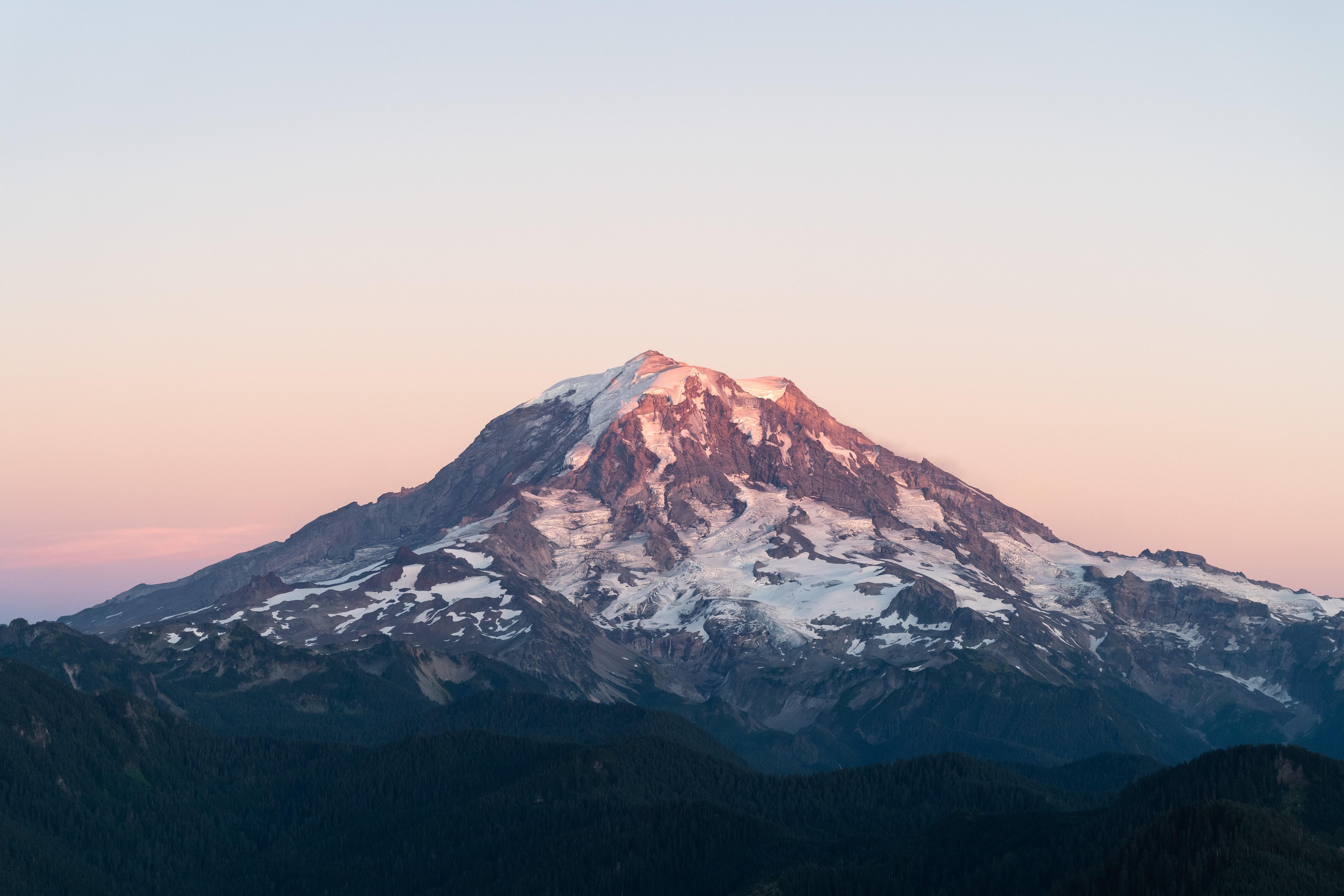 A sunset image of Rainier in the summer with patches of snow still visible